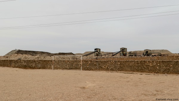 A soccer field next to a phosphate storage area