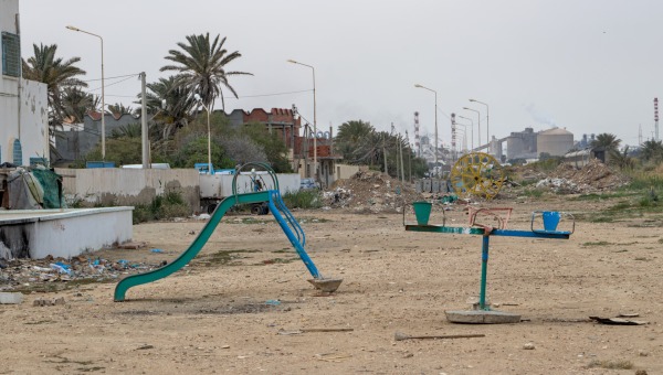 A playground in Gabes with a chemical plant in the background