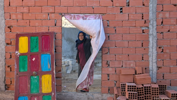 A woman stands in the doorway of her home in an informal settlement on the outskirts of Tunis.