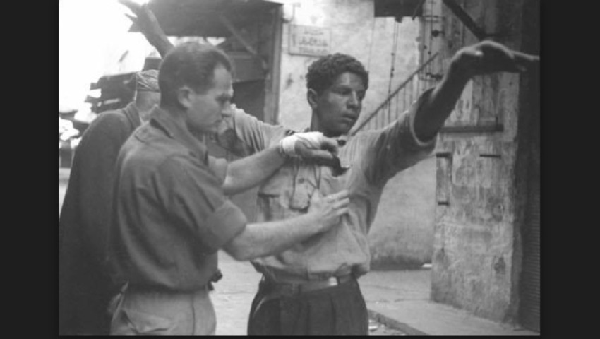 A Palestinian being searched during the occupation of Haifa, 1948. Photo by Fred Csasznik. Source: The Israel Defense Forces and Defense Establishment Archive.